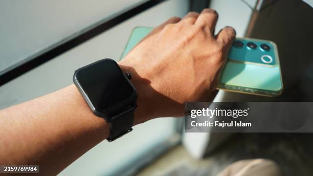 smart watch and smartphone on hand - smartwatch stock-fotos und bilder