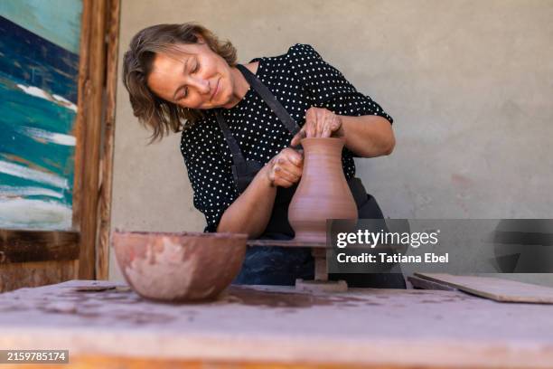 woman at pottery wheel making clay bowl - woman hobbies stock pictures, royalty-free photos & images