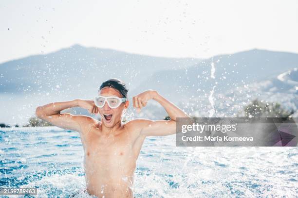 boy having fun in a pool. - infinity pool stock pictures, royalty-free photos & images