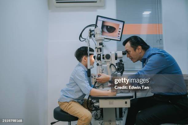 asian optometrist doing eye test with a boy - astigmatismo imagens e fotografias de stock