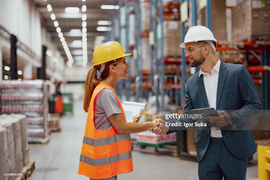 Good job!
Female warehouse worker and manager shaking hands in warehouse