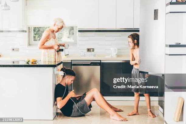 a mother and her two sons spend time in the kitchen. - battery life stock pictures, royalty-free photos & images