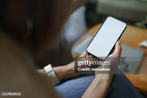 Blank screen smartphone device template mockup. Over shoulder view of hand holding smartphone. Blank screen smartphone device template mockup. Over shoulder view of hand holding smartphone.