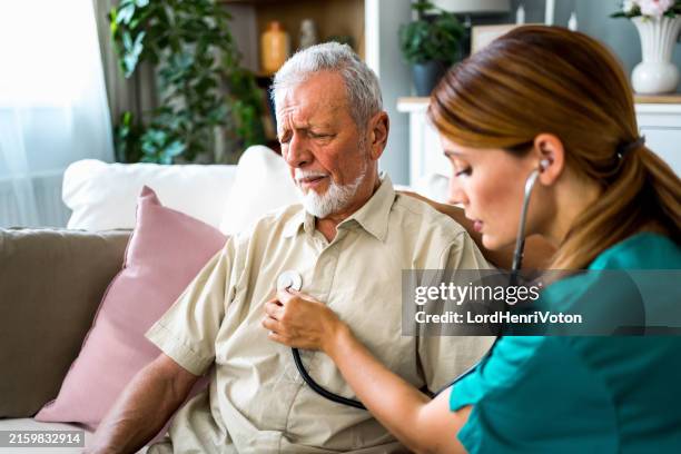 krankenschwester mit stethoskop prüft den herzschlag eines älteren mannes - herzton abhören stock-fotos und bilder