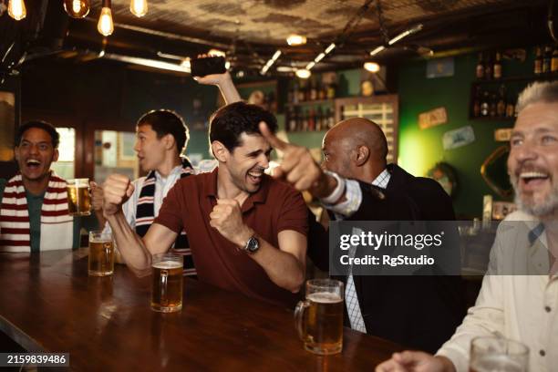 soccer lovers watching the game at the pub and cheering - sports bar stock pictures, royalty-free photos & images