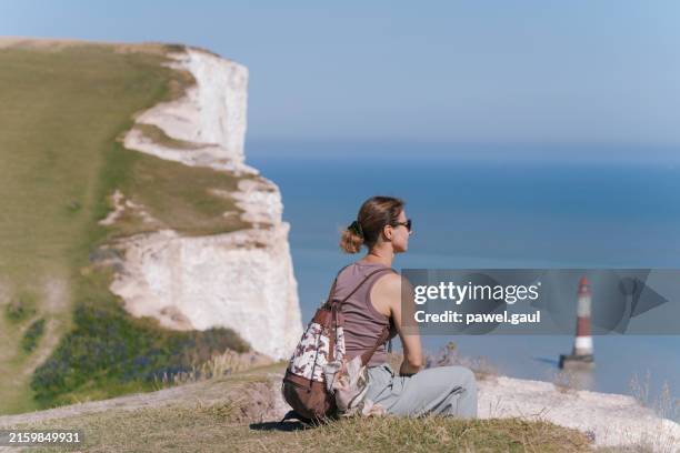 woman sitting by seven sisters cliffs, eastbourne uk - south downs national park stock pictures, royalty-free photos & images
