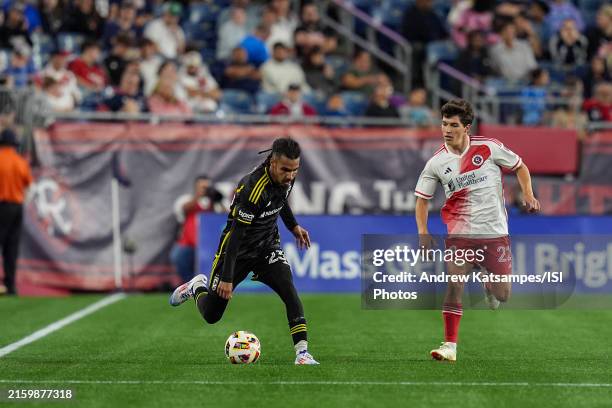 Mohamed Farsi of Columbus Crew brings the ball forward as Jack Panayotou of New England Revolution defends during a game between Columbus Crew and...