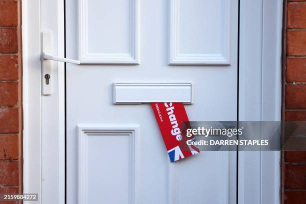 Labour Party leaflet hangs from a letter box near a polling station in Loughborough, central England, on July 4, 2024 as Britain holds a general...