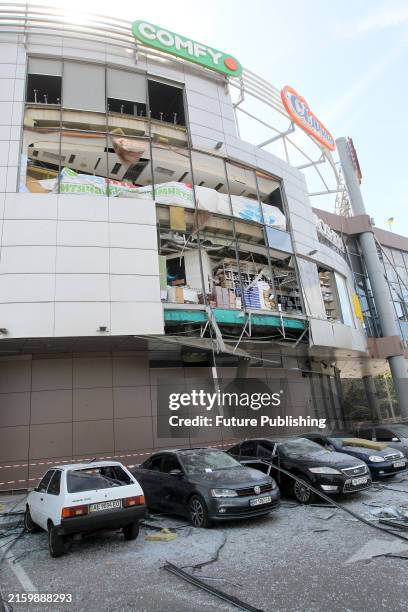 Damaged cars are pictured outside a shopping mall affected by the Russian missile strike in Dnipro, east-central Ukraine, on Wednesday morning, July...