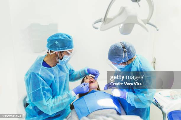 mid waist view of doctors working at dental procedure - dentisti al lavoro foto e immagini stock