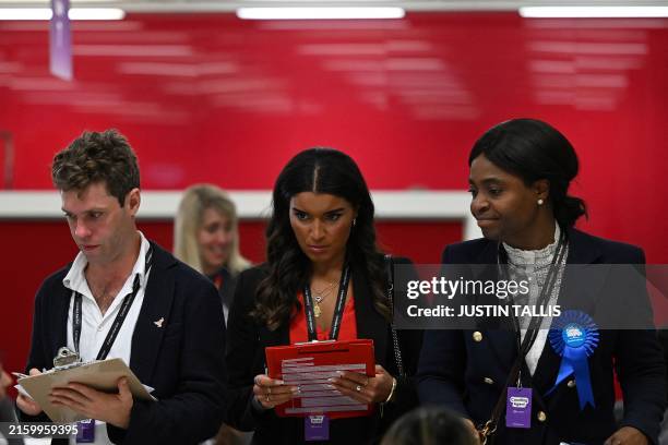 Observers from Britain's Liberal Democrats, Labour Party and Conservative Party look at ballots being sorted at the Camden Council count centre in...