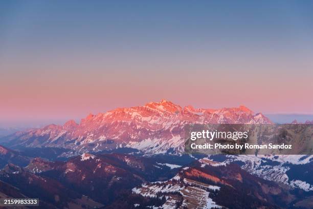 aerial of snow-covered säntis with alpenglow - alpenglühen stock-fotos und bilder