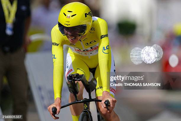 Team Emirates team's Slovenian rider Tadej Pogacar wearing the overall leader's yellow jersey cycles past the finish line of the 7th stage of the...