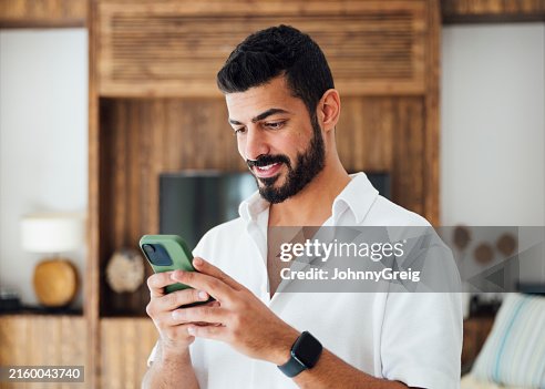 Uomo saudita adulto medio che usa lo smartphone Uomo saudita adulto medio che usa lo smartphone