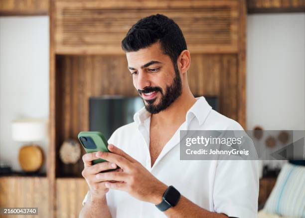 mid adult saudi man using smart phone - middle eastern people stock pictures, royalty-free photos & images