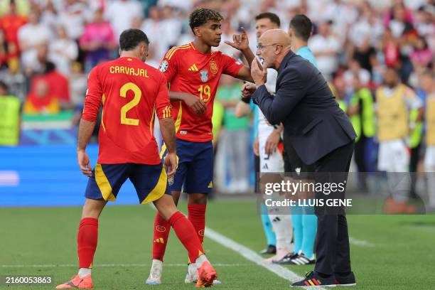 Spain's head coach Luis de la Fuente speaks to Spain's forward Lamine Yamal and Spain's defender Dani Carvajal during the UEFA Euro 2024...