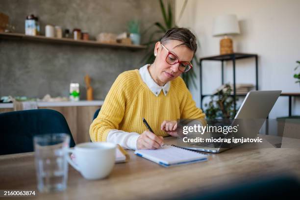 woman in her forties with gray hair using lap top at home - surfer stock pictures, royalty-free photos & images