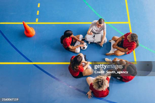 sessione di strategia di squadra guidata dall'allenatore sul campo indoor. - attività extracurricolari foto e immagini stock
