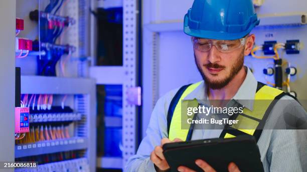 electrical engineer working in control room at industry factory. - fare stock pictures, royalty-free photos & images