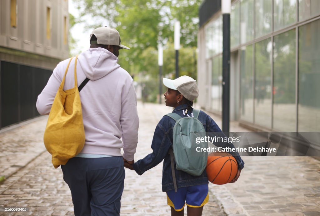 A dad accompaning his 9 year old daughter to her basketball class