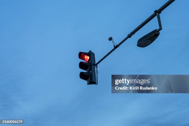 red traffic light against evening sky - red light night stock pictures, royalty-free photos & images