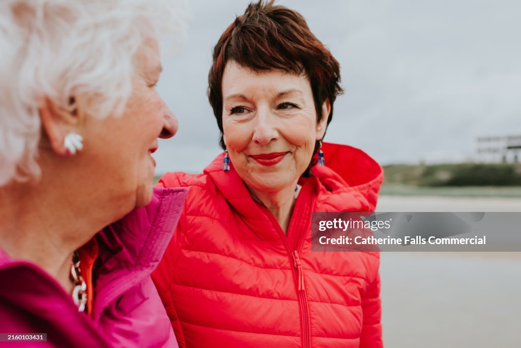 A mature woman gazes at her elderly mother with love and kindness