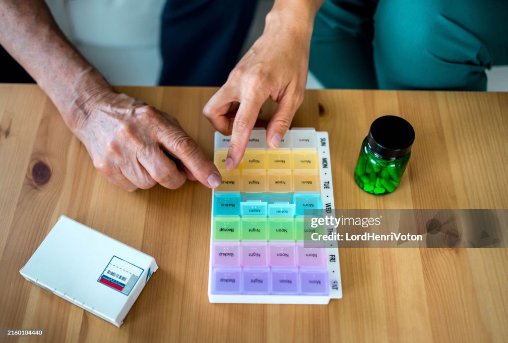 Home nurse helps senior patient organize medication