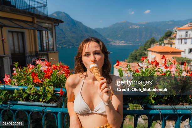 donna che mangia gelato durante la sua vacanza sul lago di como - cucchiaio dosatore foto e immagini stock