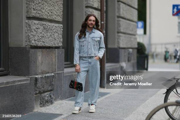 Riccardo Simonetti is seen wearing one large earring with rhinestones in shape of a cross also a small silver hoop earring, a two-piece from United...