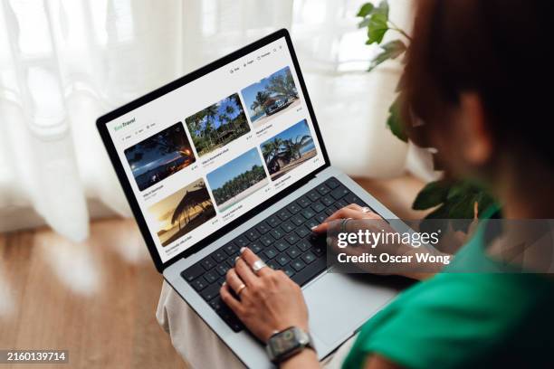 young woman planning a sustainable travel with laptop - web screen stock-fotos und bilder