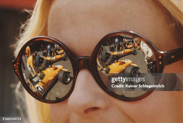 McLaren M14A Fords reflected in a woman's sunglasses in the pits during the French GP at Circuit de Charade on July 04, 1970 in Circuit de Charade,...