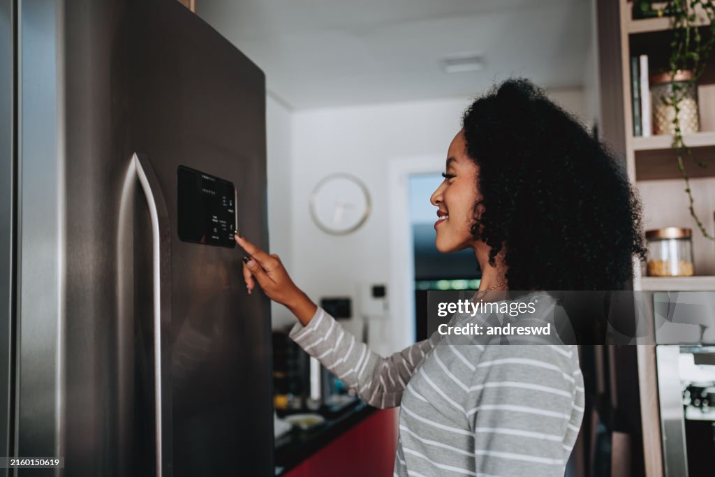 Woman using smart refrigerator checking information