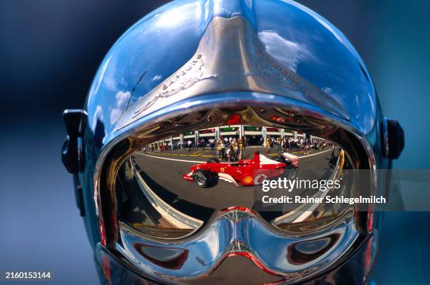 Michael Schumacher, Ferrari F2002, reflected in the visor of a fire marshal during the French GP at Circuit de Nevers Magny-Cours on July 21, 2002 in...