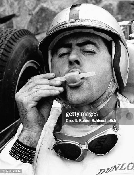 Jack Brabham enjoys an ice lolly in the cockpit of his Lotus 24 Climax during the Belgian GP at Spa-Francorchamps on June 17, 1962 in...