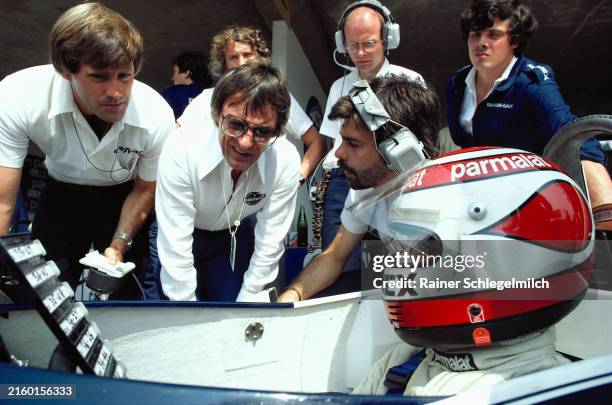 Nelson Piquet, Brabham BT49C Ford, studies lap times along with Bernie Ecclestone and Gordon Murray in the pits during the Austrian GP at the...