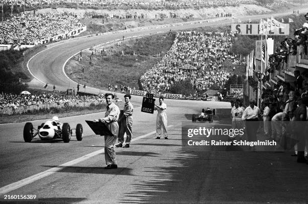 View from the pits looking downhill towards Eau Rouge, as mechanics hold pitboards to signal to drivers during the Belgian GP at Circuit de Spa...