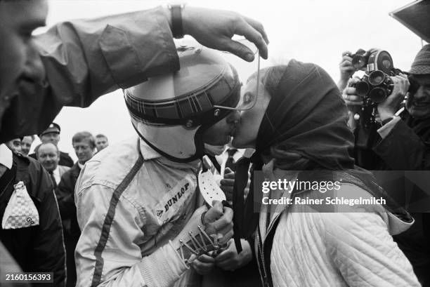 Helen Stewart kisses her husband, Jackie, after his win. Jackie's visor is held up as his broken wrist is in a cast during the Dutch GP at Circuit...