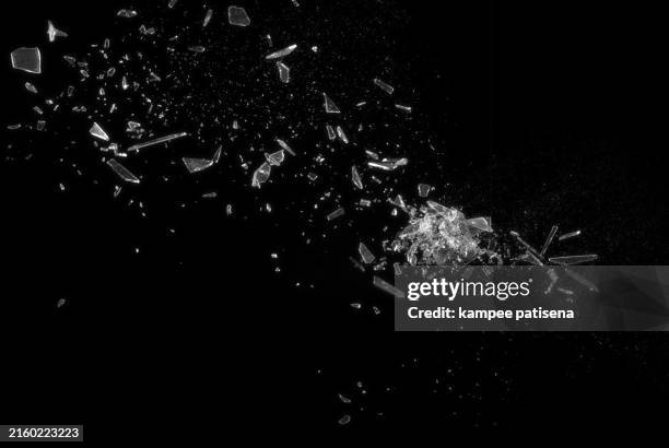 broken glass on black background shows the abstract texture of the shattered glass in great detail. the image is perfect for use in backgrounds, textures, or abstract art projects. - verre brisé photos et images de collection