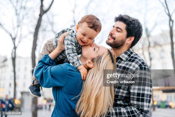 mid-adult man and woman playing with their toddler son on the street in paris - young family stock pictures, royalty-free photos & images