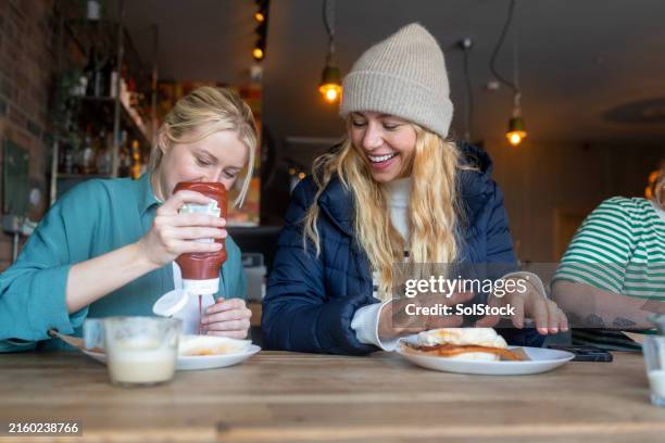 adding ketchup to her breakfast - tomato sauce stock pictures, royalty-free photos & images