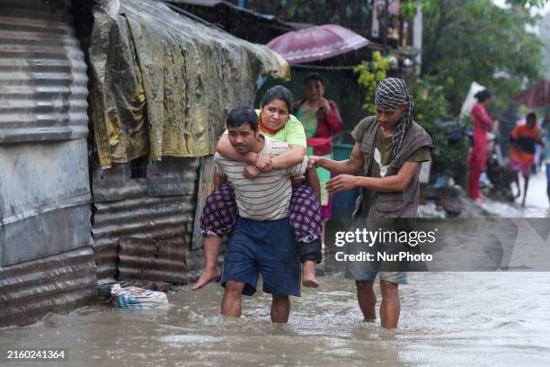Man in Nepal is carrying a member of his family who is under a diagnosis while wading through the flood in Kathmandu, Nepal, on July 6, 2024.