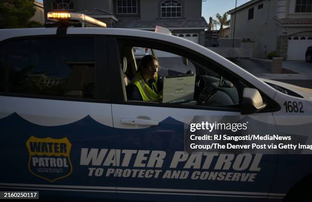 Las Vegas Valley Water District Water Waste Investigator Devyn Choltko puts a water waste violation into the computer system outside a home in North...