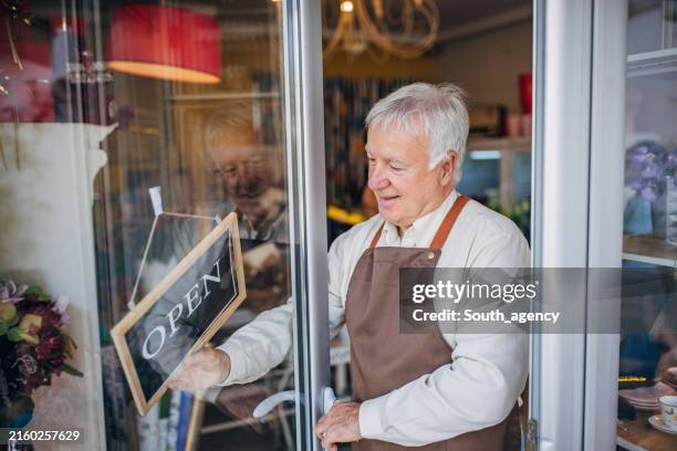florist opening flower shop for customers, arms folded. - welvaart stockfoto's en -beelden