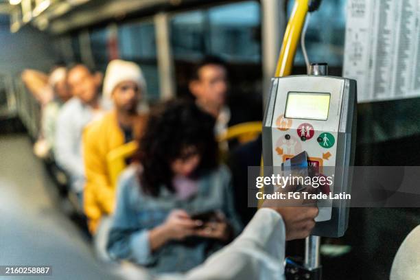 nahaufnahme von frauen, die das busticket mit karte im bus bezahlen - öffentliches verkehrsmittel stock-fotos und bilder