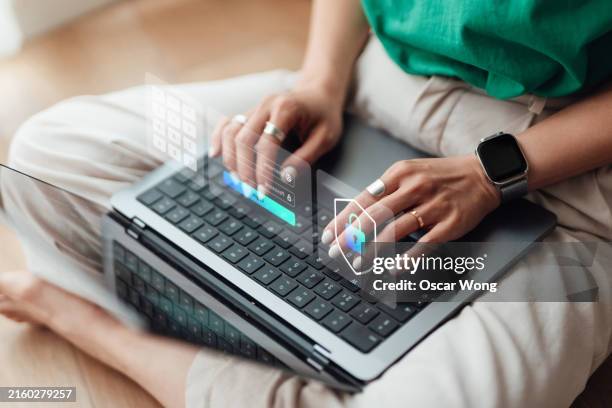 female hand interacting with virtual interface while managing online security system with laptop - computer virus stockfoto's en -beelden