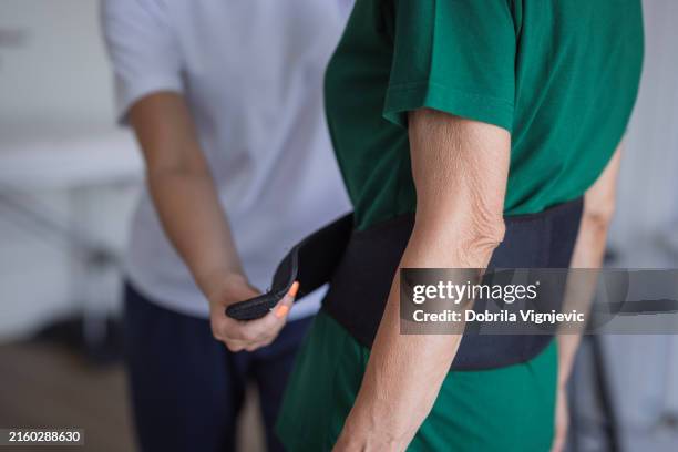 woman wearing back pain support belt - orthopedic belts stock pictures, royalty-free photos & images
