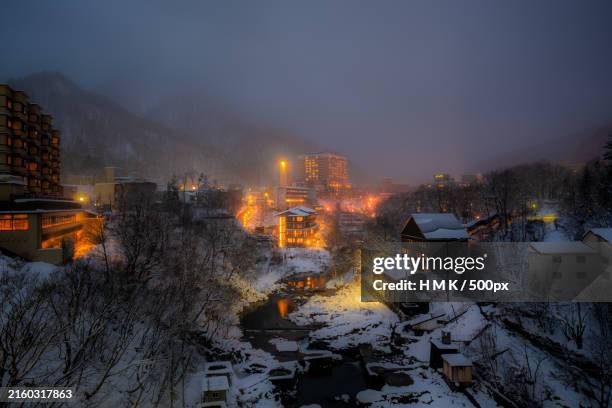 high angle view of illuminated buildings at night during winter,japan - satoyama-scenery foto e immagini stock