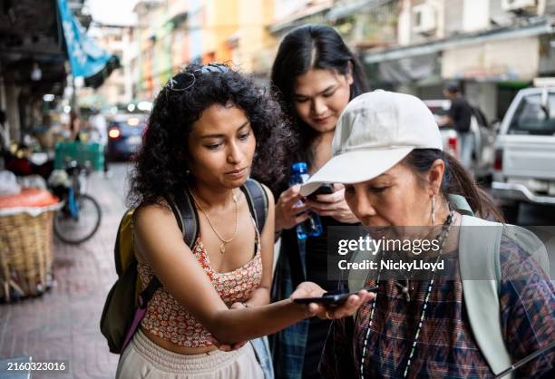 touristes féminines et guide touristique utilisant le téléphone pour la traduction lors de la visite de la ville - reconnaissance vocale photos et images de collection