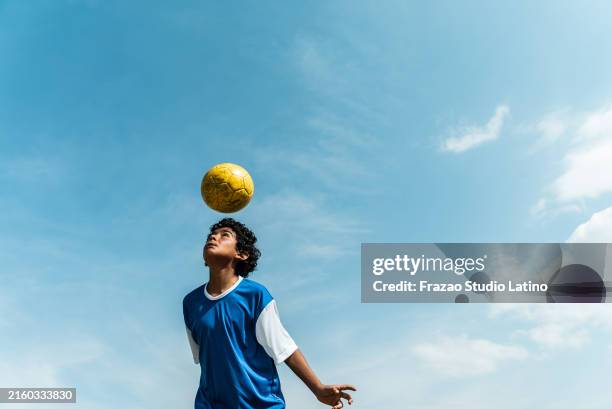 child boy juggling ball in the soccer field - football sport stock pictures, royalty-free photos & images