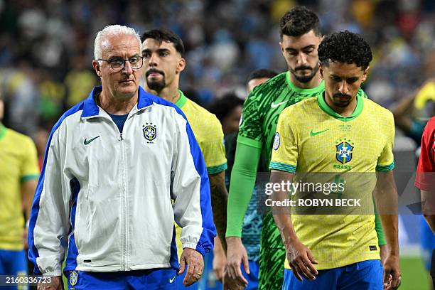 Brazil's coach Dorival Junior and Brazil's defender Marquinhos react after their team's defeat in the Conmebol 2024 Copa America tournament...